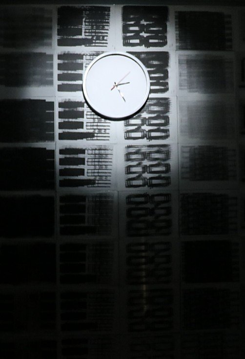 Reloj iluminado sobre el muro de grabados